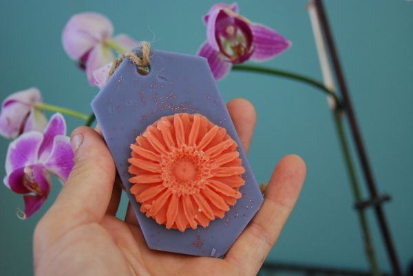suspension parfumée violette et ovale avec fleur orange au milieu