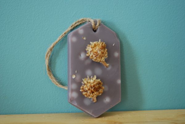 Suspension parfumée de forme ovale marron avec point blanc ainsi que des fleurs séchèes